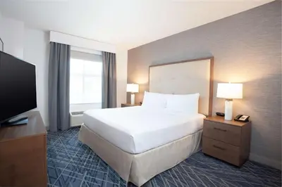 a hotel room with a bed and a flat screen tv at Homewood Suites By Hilton Broomfield Boulder in Broomfield