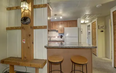 a kitchen with a counter with stools and a refrigerator at B207 Ten Mile Island 2Br 2Ba condo in Frisco