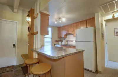 a kitchen with a white refrigerator and wooden cabinets at B207 Ten Mile Island 2Br 2Ba condo in Frisco