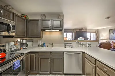 a kitchen with wooden cabinets and white counter tops at Condo with Balcony and Fireplace in Silverthorne! in Silverthorne