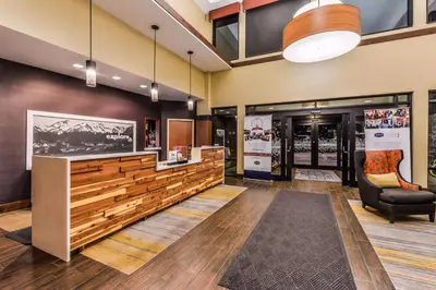 a lobby with a bench and a chair in a building at Hampton Inn & Suites Boulder North in Boulder