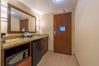 a bathroom with a sink and a mirror and a door at Hampton Inn & Suites Boulder North in Boulder