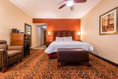 a hotel room with a bed and a chair at Hampton Inn & Suites Boulder North in Boulder