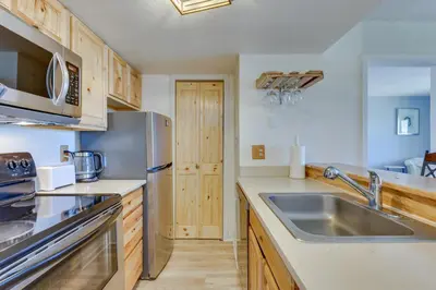a kitchen with a sink and a refrigerator at Ski-InandOut Granby Condo with Mtn Views and Balcony! in Granby