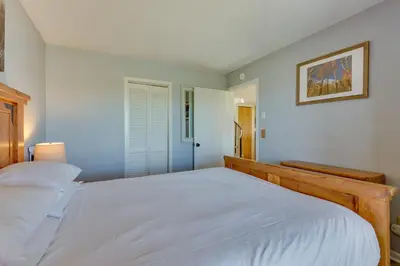 a bedroom with a large white bed and a window at Ski-InandOut Granby Condo with Mtn Views and Balcony! in Granby