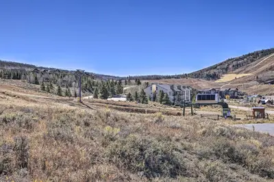a house in the middle of a field with trees at Ski-InandOut Granby Condo with Mtn Views and Balcony! in Granby