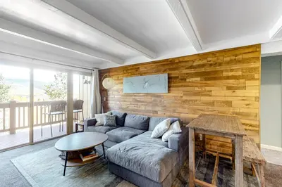a living room with a couch and a wooden wall at Mountain Views & Meadows in Silverthorne