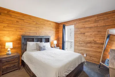 a bedroom with a bed and a wooden wall at Mountain Views & Meadows in Silverthorne