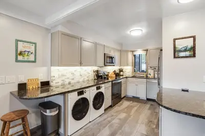 a kitchen with white cabinets and white appliances at Mountain Views & Meadows in Silverthorne