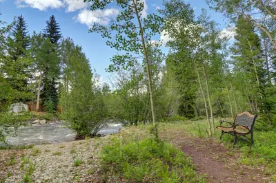 a bench sitting in a field next to a river at 101 Streamside Lane condo in Frisco