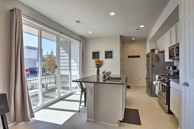 a kitchen with a counter and a large window at Near Hiking and Biking Trails Townhome with Patio in Aurora