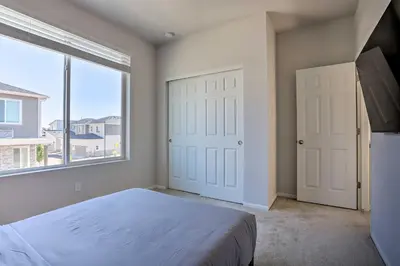 a bedroom with a bed and a large window at Near Hiking and Biking Trails Townhome with Patio in Aurora