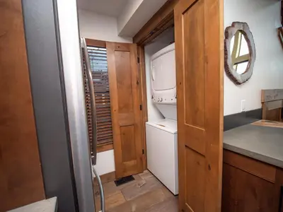 a small kitchen with a washer and dryer at Private end unit with Jacuzzi, Two Patios, and Indoor/Outdoor Fireplace in Estes Park
