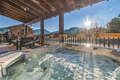 a hot tub on the deck of a house at Private end unit with Jacuzzi, Two Patios, and Indoor/Outdoor Fireplace in Estes Park