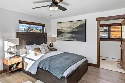 a bedroom with a bed and a ceiling fan at Private end unit with Jacuzzi, Two Patios, and Indoor/Outdoor Fireplace in Estes Park