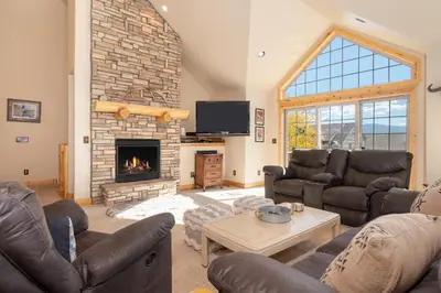 a living room with couches and a fireplace at 67 Fireweed 27A by Stay Winter Park in Tabernash