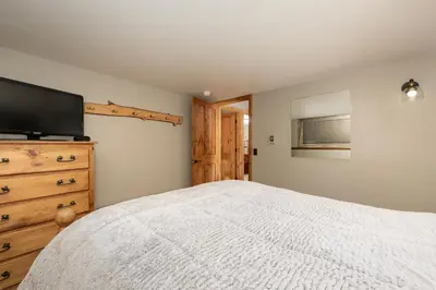 a bedroom with a bed and a flat screen tv at 59 Jabberwocky Home by Stay Winter Park in Fraser