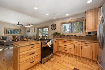 a kitchen with wooden cabinets and a stove top oven at 59 Jabberwocky Home by Stay Winter Park in Fraser