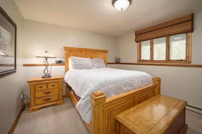 a bedroom with a wooden bed and a window at 59 Jabberwocky Home by Stay Winter Park in Fraser