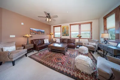 a living room with leather furniture and a piano at Cozens Pointe Building I Unit I201 by Stay Winter Park in Fraser