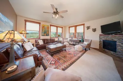 a living room with leather furniture and a fireplace at Cozens Pointe Building I Unit I201 by Stay Winter Park in Fraser