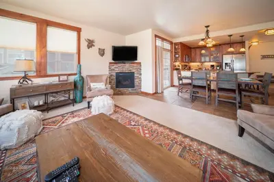 a living room with a fireplace and a dining room at Cozens Pointe Building I Unit I201 by Stay Winter Park in Fraser