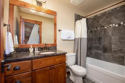 a bathroom with a sink and a toilet and a tub at Cozens Pointe Building I Unit I201 by Stay Winter Park in Fraser