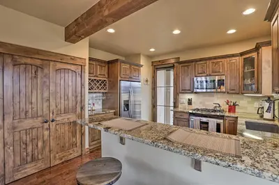 a kitchen with wooden cabinets and a counter top at Luxurious Fraser Townhome with Private Hot Tub! in Fraser