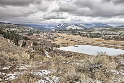 a lake in a field with snow capped mountains at Luxurious Fraser Townhome with Private Hot Tub! in Fraser