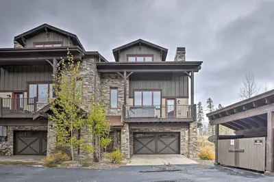 a large stone house with a garage at Luxurious Fraser Townhome with Private Hot Tub! in Fraser