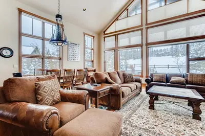 a living room with leather furniture and large windows at Gray Moose in Breckenridge