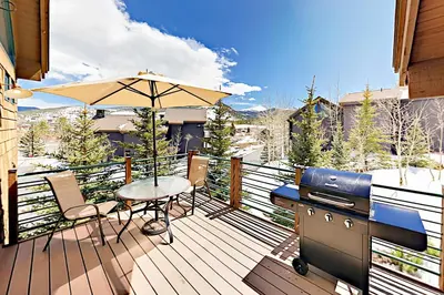 a deck with a grill and a table and an umbrella at Gray Moose in Breckenridge