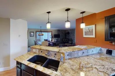a kitchen with a marble counter top with a sink at Quaint Mountain Condo in Frisco