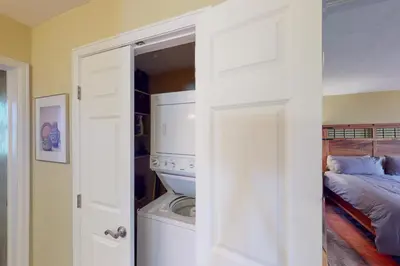 a bedroom with a washer and dryer next to a bed at Quaint Mountain Condo in Frisco