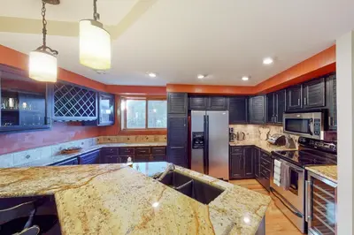 a large kitchen with blue cabinets and an island at Quaint Mountain Condo in Frisco