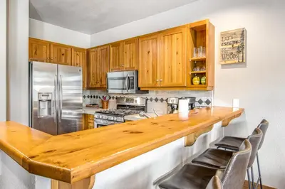 a kitchen with wooden cabinets and a wooden counter top at Alpine Holidays Ski Tip in Keystone