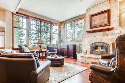 a living room with a large stone fireplace at Moose Whiskers in Keystone