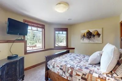 a bedroom with a bed and a flat screen tv at Moose Whiskers in Keystone