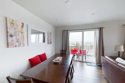 a living room with a dining table and a living room with a balcony at La Bonte Townhomes Unit 304 in Dillon