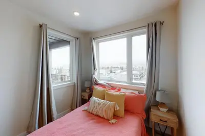 a bedroom with a bed and two large windows at La Bonte Townhomes Unit 304 in Dillon