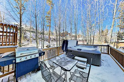 a patio with a grill and a table on a deck at Saddle Ridge Townhome 402 in Silverthorne