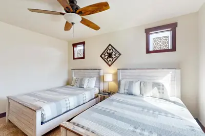 two beds in a bedroom with a ceiling fan at Blue River Condo Unit 203 in Silverthorne