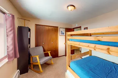 a bedroom with two bunk beds and a chair at Mountian View Condo Unit S303 in Dillon