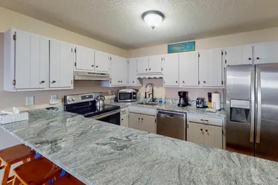 a kitchen with white cabinets and a granite counter top at Mountian View Condo Unit S303 in Dillon