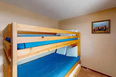 a bedroom with a bunk bed with blue sheets at Mountian View Condo Unit S303 in Dillon