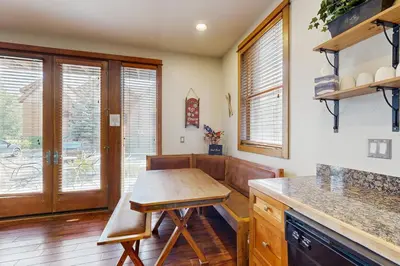 a kitchen with a wooden table and some windows at Hop Inn At Antlers Gulch in Keystone