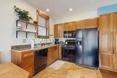 a kitchen with wooden cabinets and a stainless steel refrigerator at Hop Inn At Antlers Gulch in Keystone