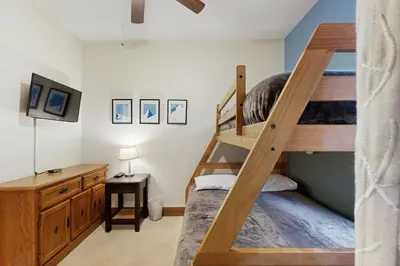 a bedroom with two bunk beds and a desk at Hop Inn At Antlers Gulch in Keystone