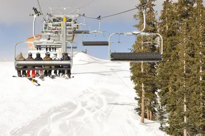 a group of people on a ski lift in the snow at Hop Inn At Antlers Gulch in Keystone