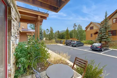 a table and chair on a porch with a parking lot at Hop Inn At Antlers Gulch in Keystone